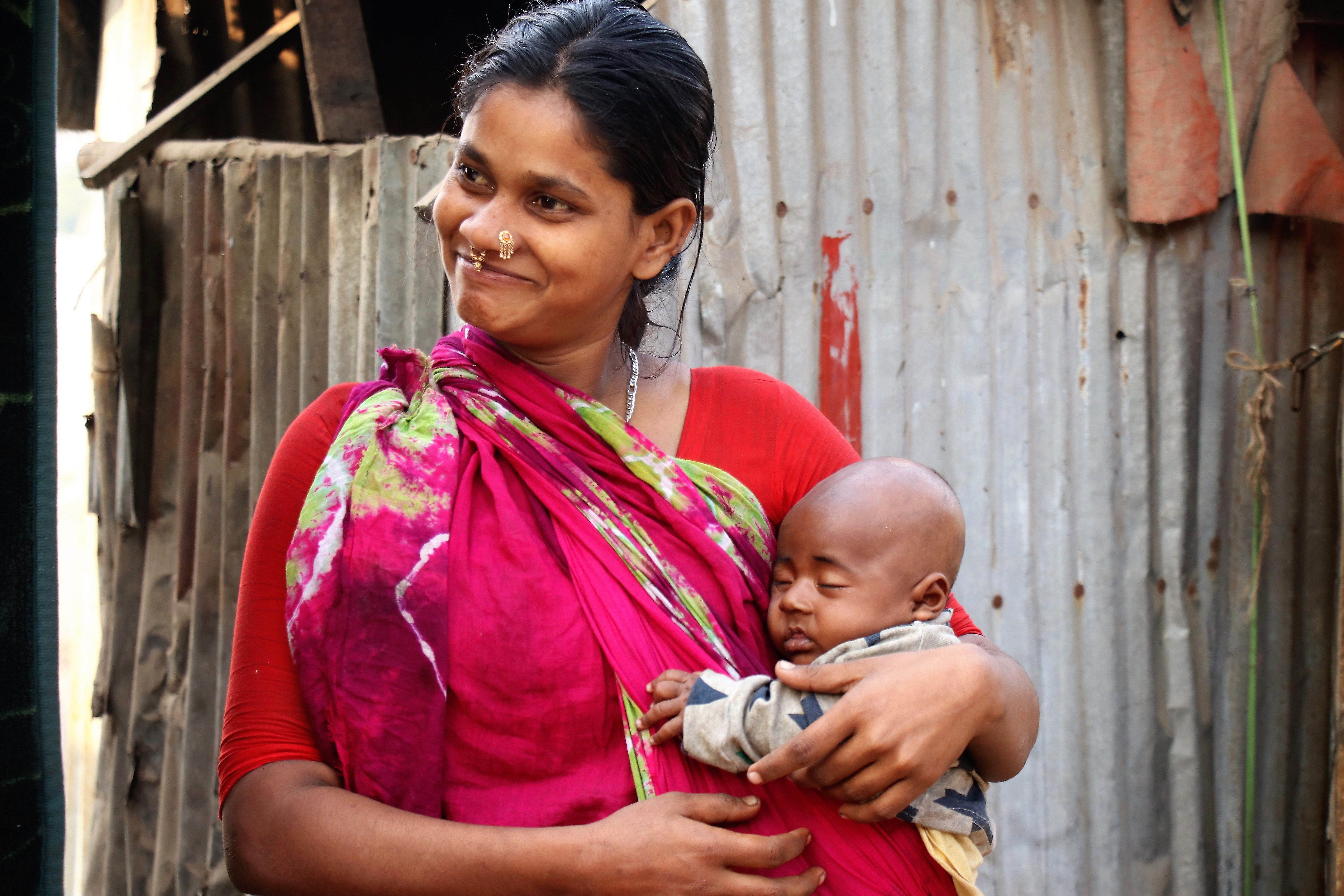 A mother lovingly holds her baby in the Gabtoli Sweeper Colony, Dhaka.