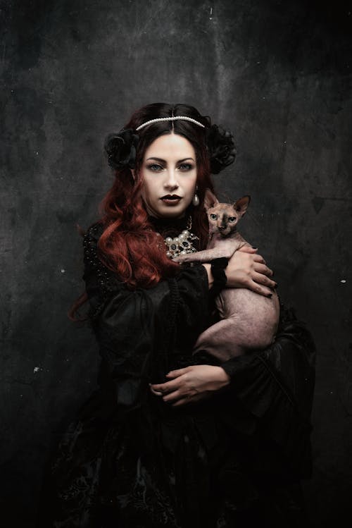 Woman in Black Dress Holding a Cat