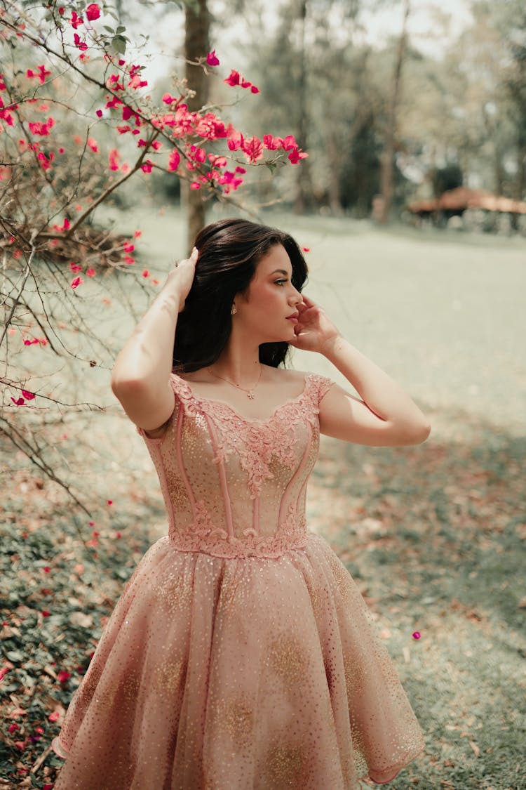 A Woman In Pink Dress Looking Over Shoulder