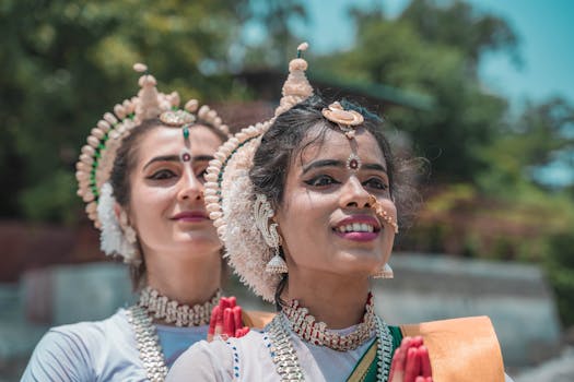 Two women performing Odissi dance, showcasing cultural heritage and traditional Indian attire.
