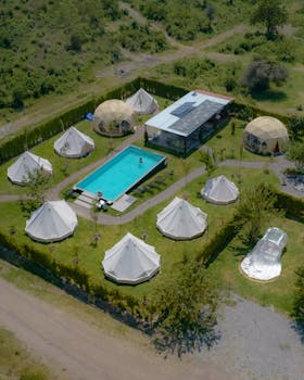 Aerial view of a luxurious glamping site featuring tents and a pool in Atlixco, Mexico.