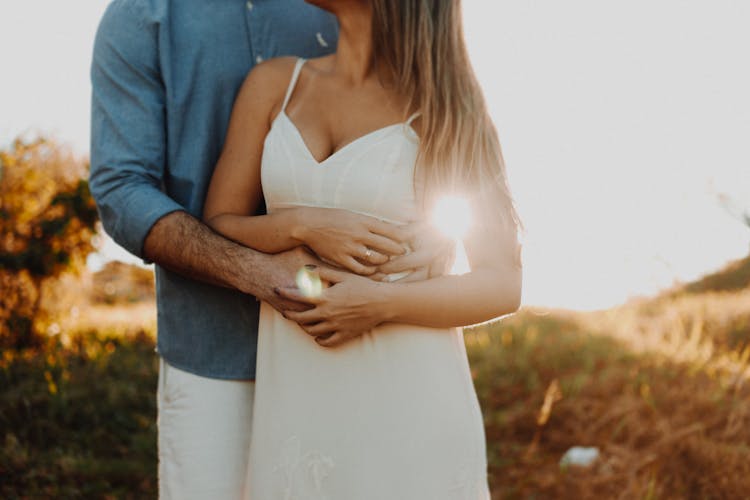 Man Holding A Woman In White Dress