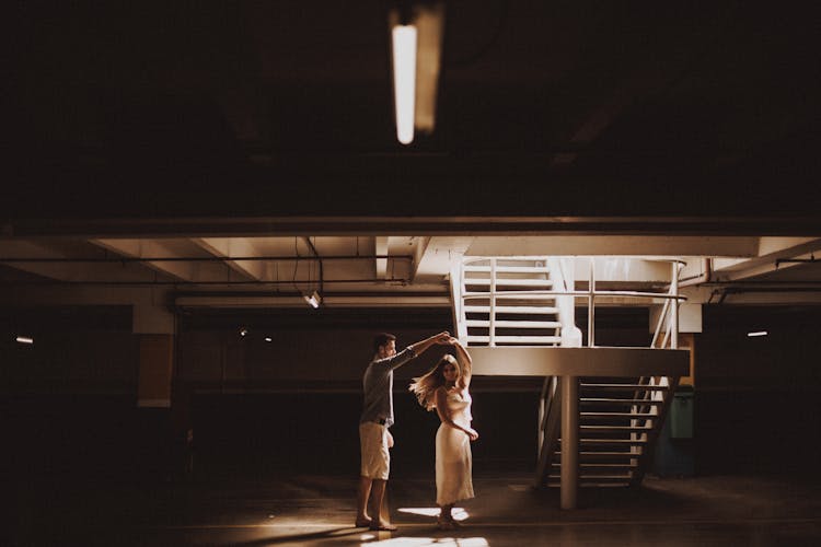 A Man And A Woman Dancing Near A Staircase