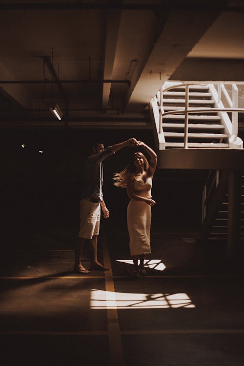 Photo of a Couple Dancing Near a Staircase