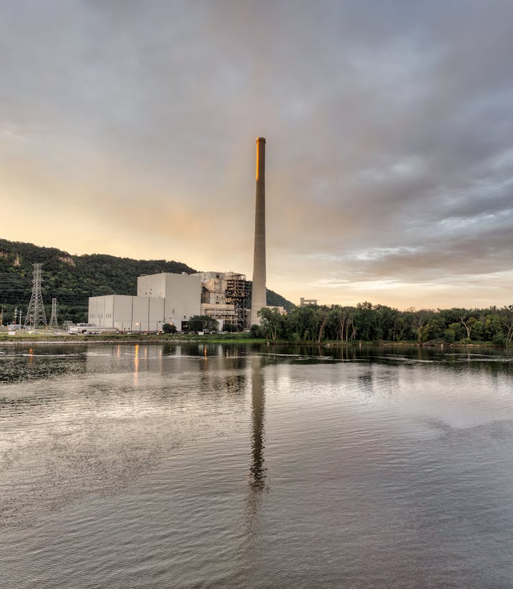 Factory Chimney Reflected In Lake