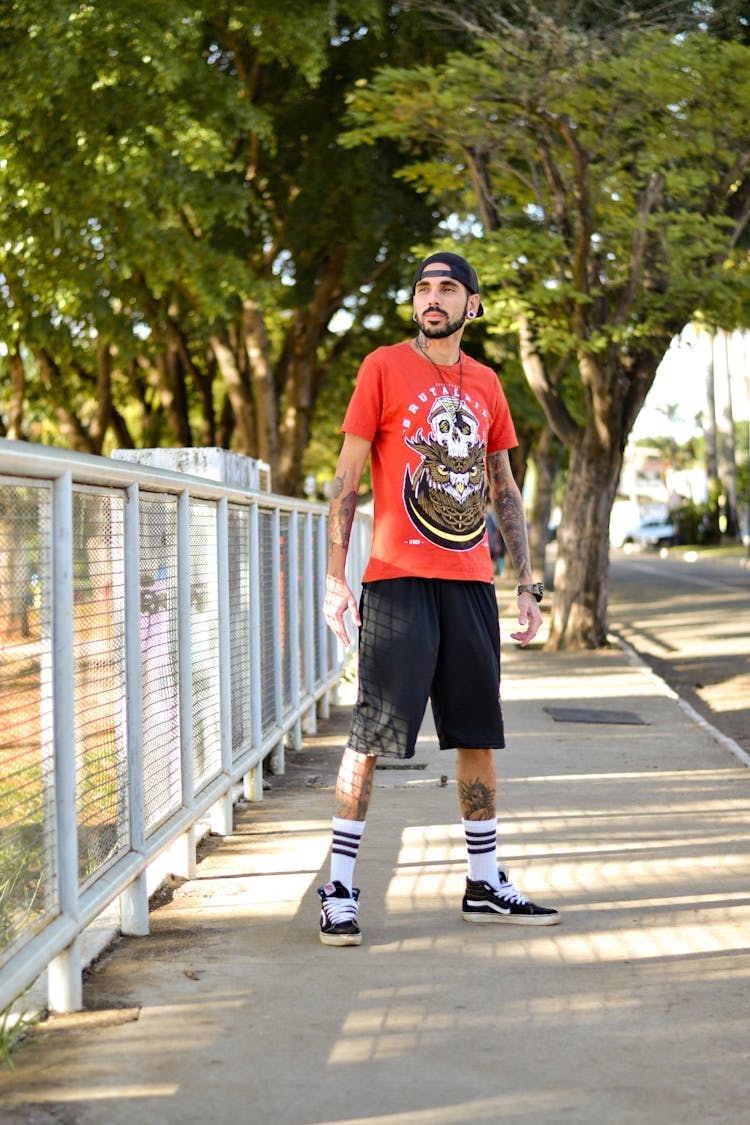 A Man In Red Shirt Standing On Sidewalk