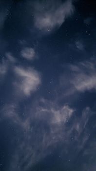 A serene night sky filled with stars and scattered clouds, perfect for celestial-themed content.