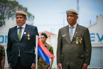 Man in Brown Police Uniform Standing Near Blue Textile