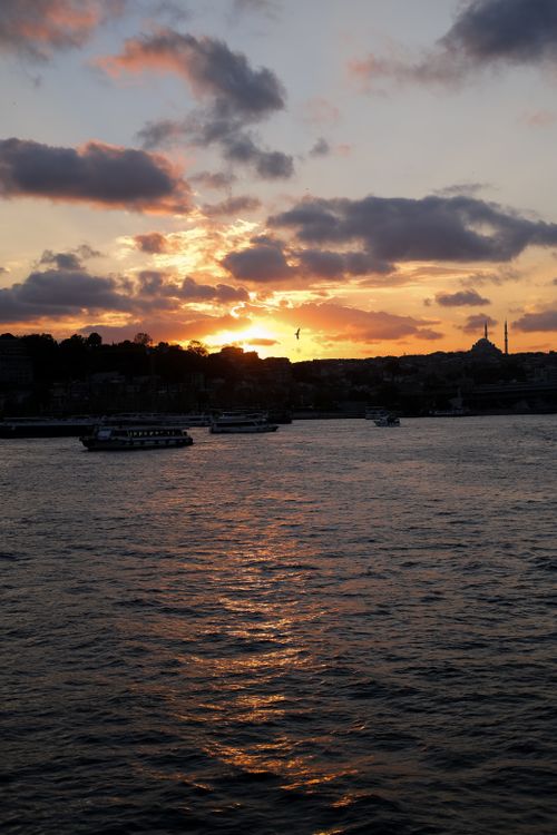Free A stunning sunset over Istanbul's Bosphorus with silhouettes of mosques and boats creating a serene scene. Stock Photo