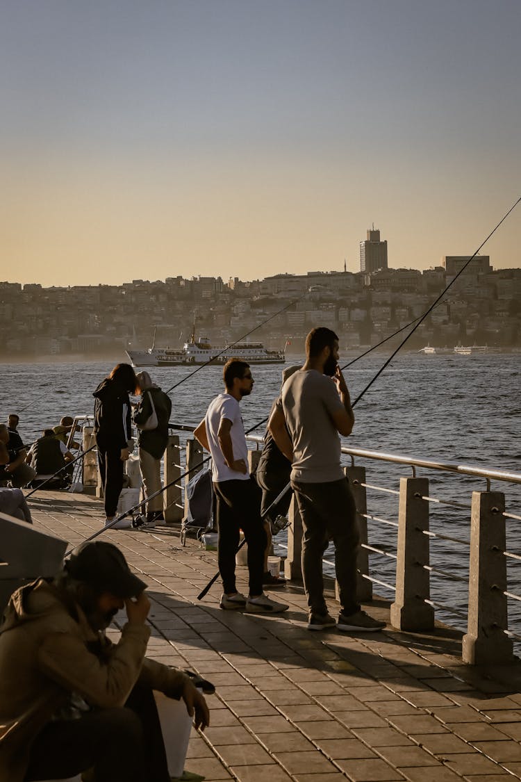 Men With Rods Fishing At City Bridge