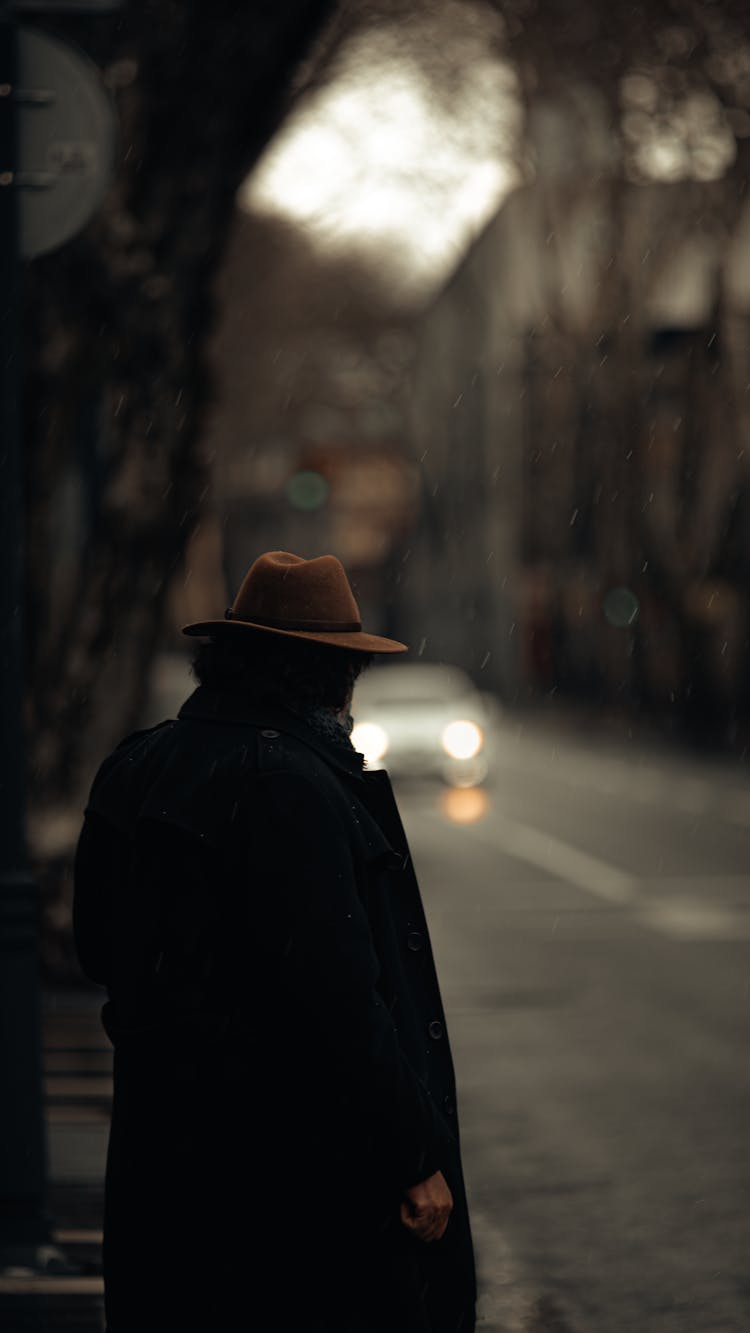 Person Wearing Hat Standing On Sidewalk