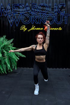 Focused woman in fitness attire exercises with kettlebell in an indoor studio.