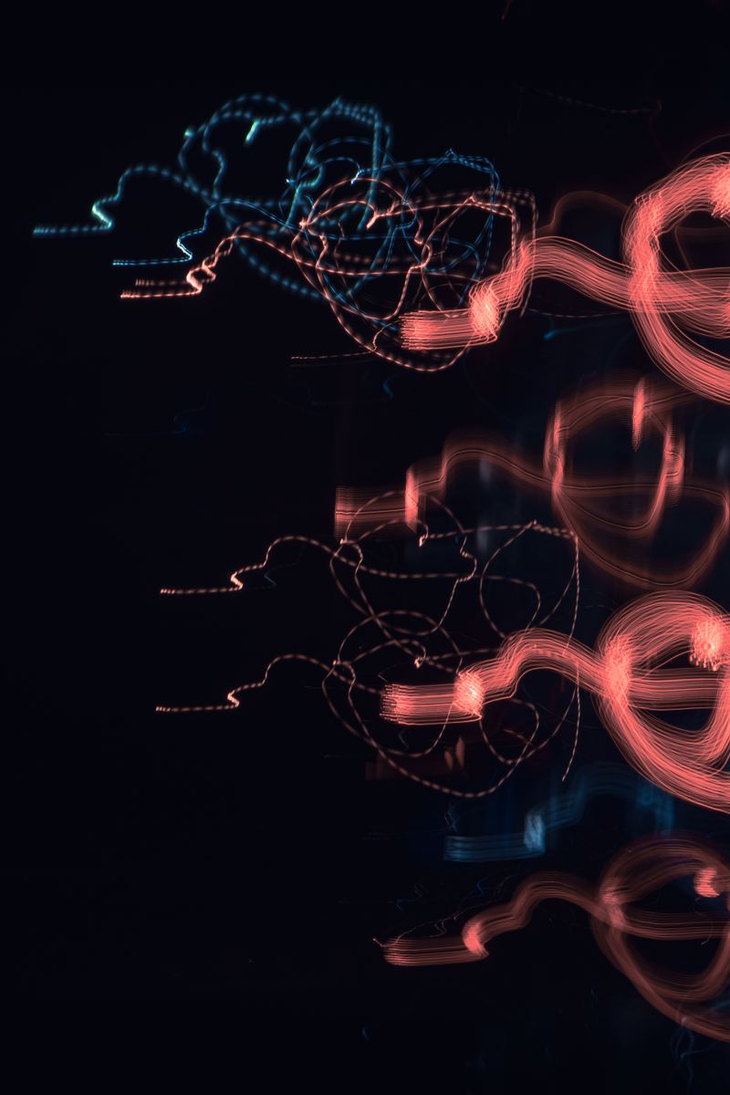 Vibrant abstract light patterns with red and blue on a dark background, creating a dynamic visual effect.
