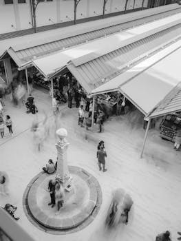 Black and white aerial view of a lively market in Porto, Portugal, showcasing bustling activity and architectural details.