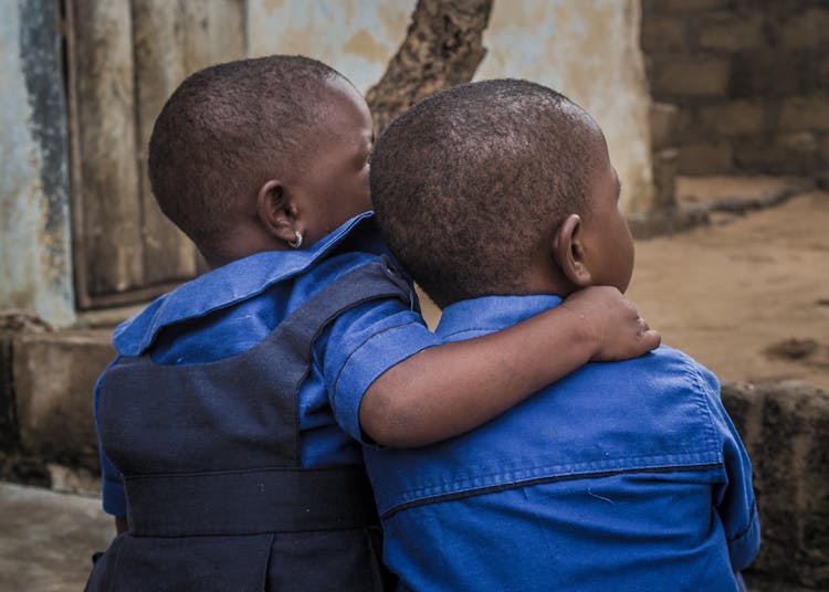 Little Girl With Arm Around Her Twin Brother