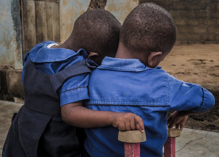 Young Children In Blue Shirts Hugging 