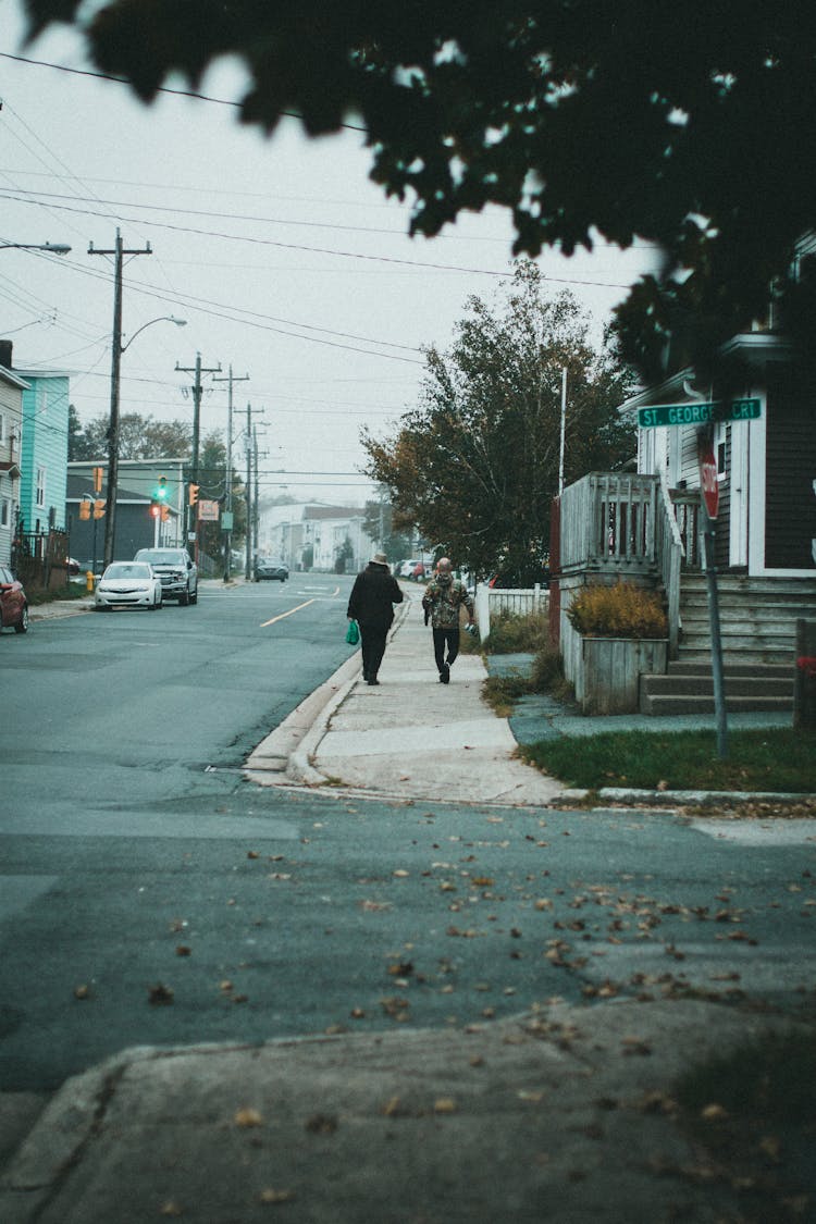 People Walking On A Sidewalk At A Neighborhood