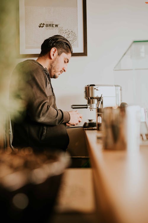 A Man in Gray Jacket Making Coffee