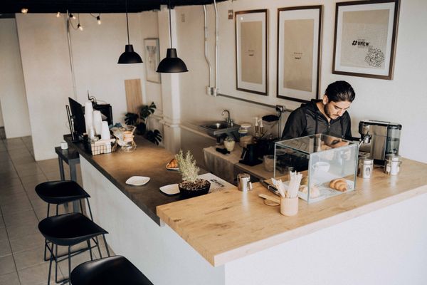 A barista works in a modern cafe with warm lighting
