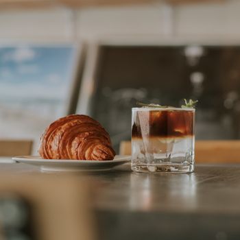 Appetizing croissant and iced coffee on a table capturing the essence of a relaxed cafe atmosphere.