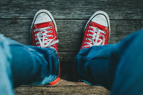 Free Vibrant red sneakers on rustic wooden planks, perfect for casual fashion inspiration. Stock Photo