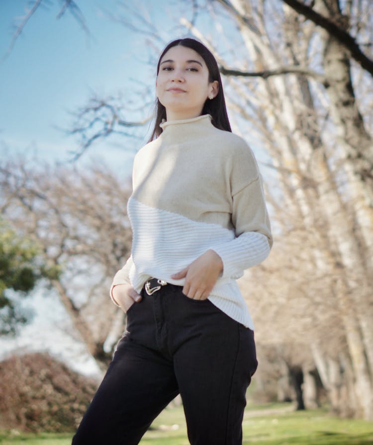 A Woman Wearing A Sweater And Black Pants