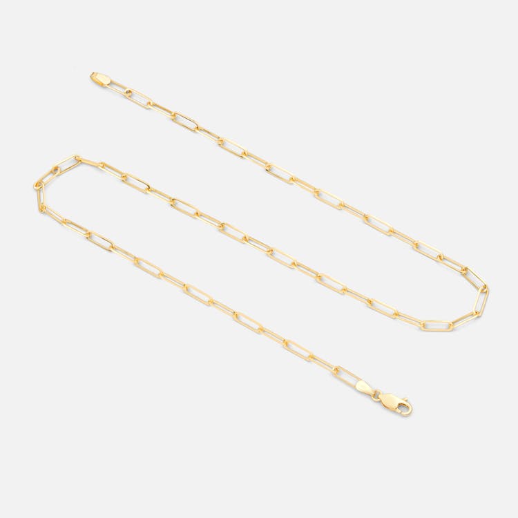 A Gold Chain Necklace On White Surface