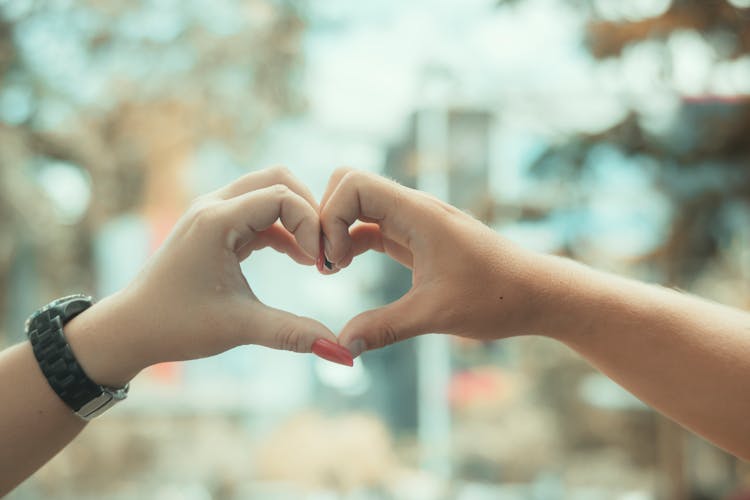 Close-up Of Couple Showing Heart With Hands