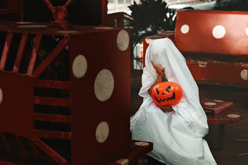 A Person in Halloween Costume Holding a Plastic Pumpkin
