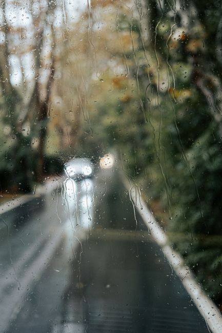 Artistic capture of a rainy day sight with water droplets on glass obscuring a road