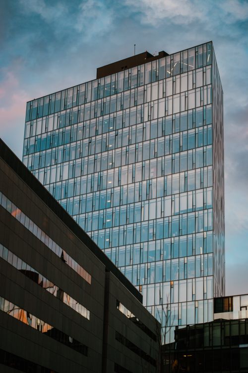 Free Tall glass skyscraper reflecting evening light, showcasing contemporary urban architecture. Stock Photo