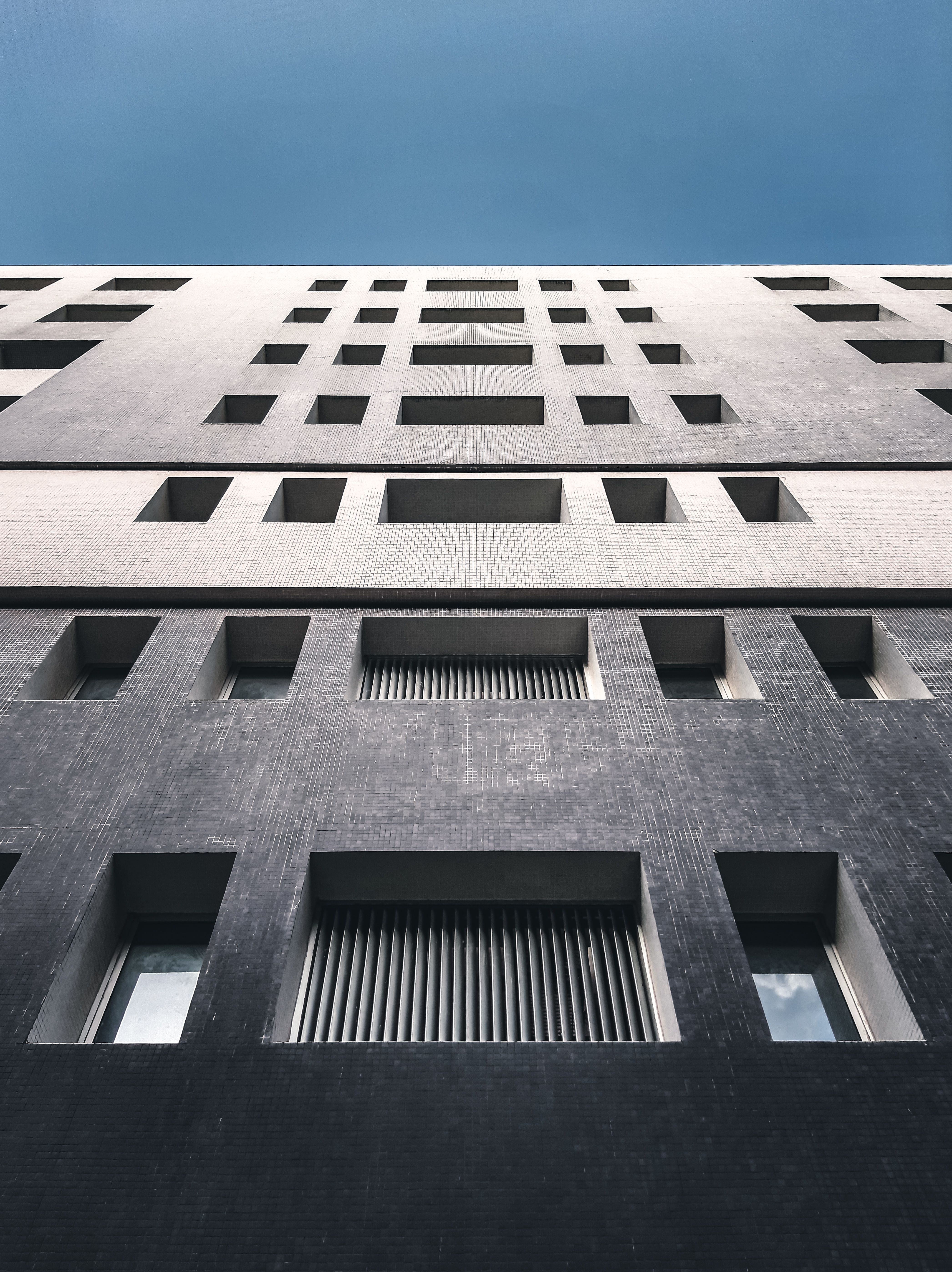 Low Angle Shot of Tall Building Under Blue Sky · Free Stock Photo