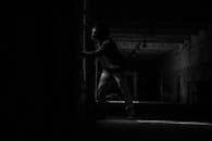 一张戏剧性的黑白照片，展现了一个戴着防毒面具的男人身处黑暗、被遗弃的空间里