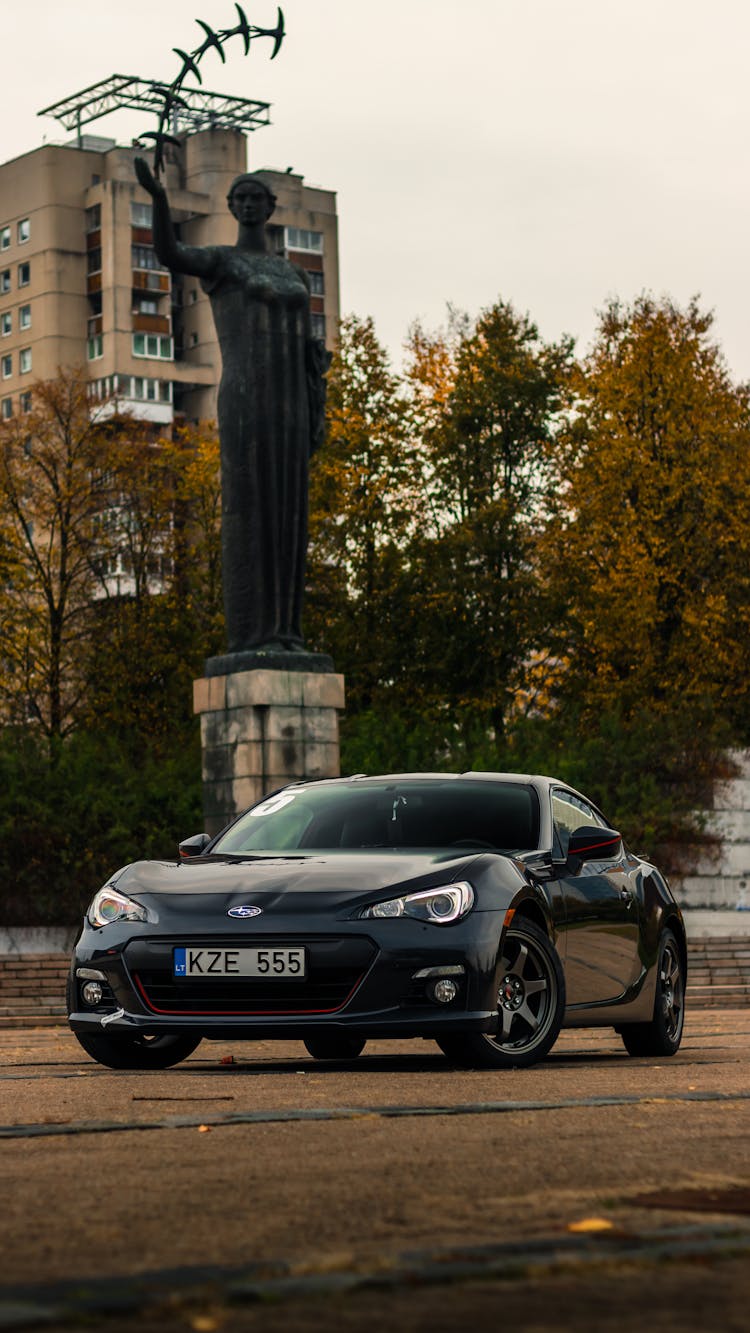 A Black Car Near A Statue