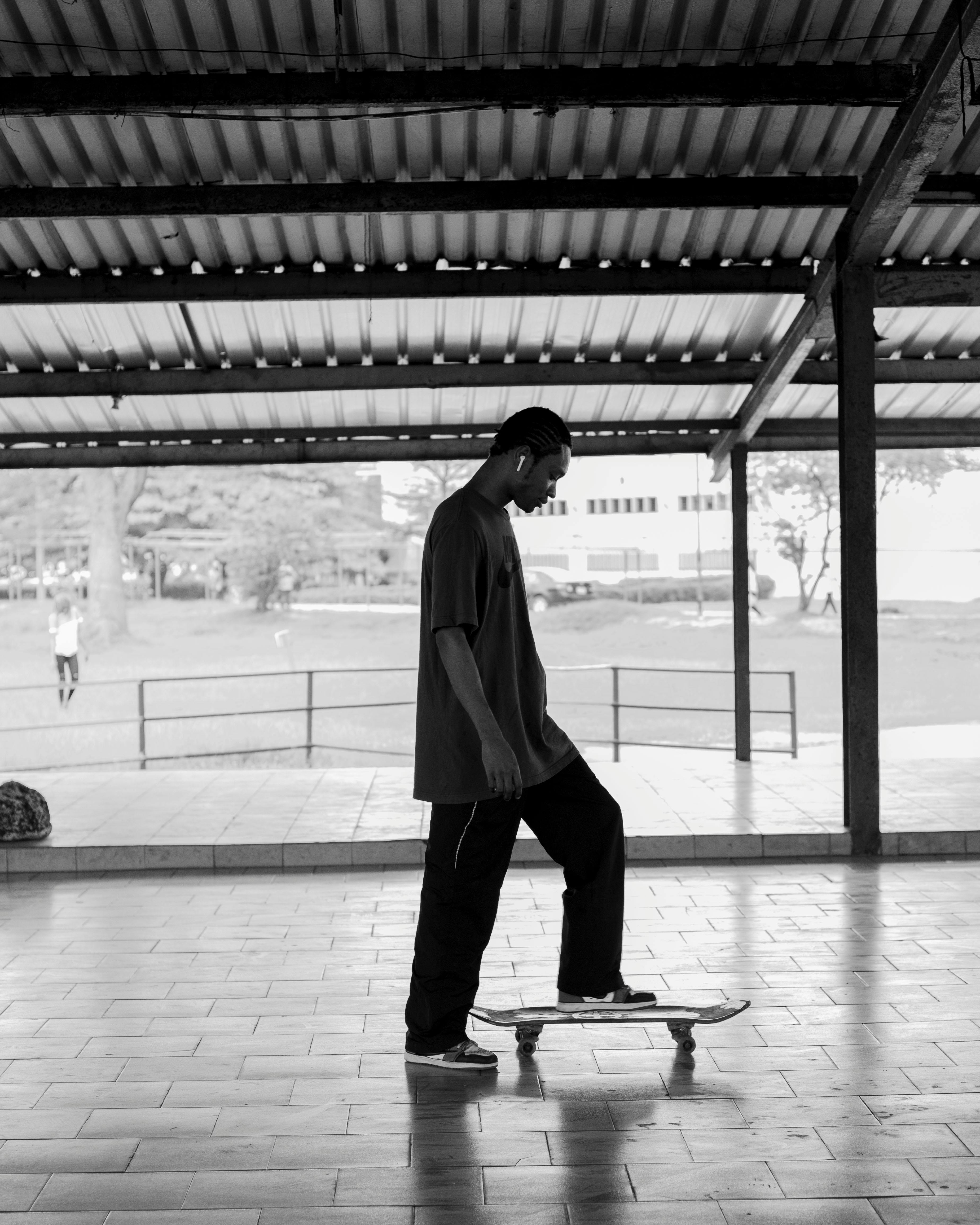 Black and white photo of a skateboarder practicing indoors at an urban park.