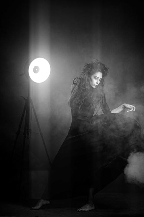Black and White Photo of a Woman in Stage Fog