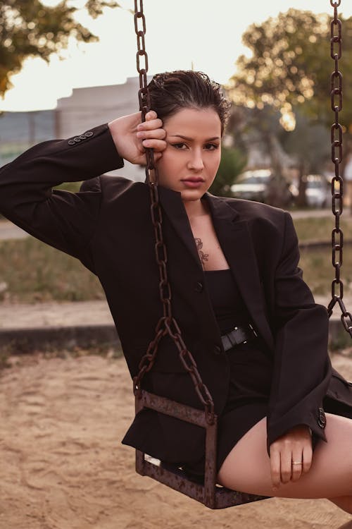 Woman in Black Blazer Sitting on Swing