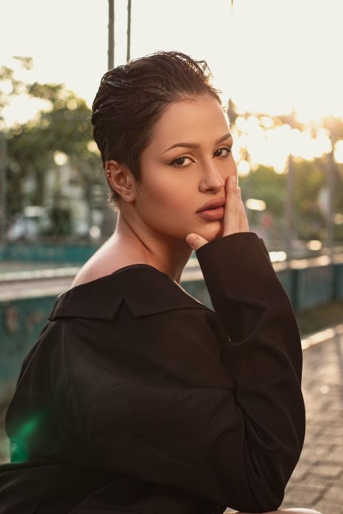 Free Elegant portrait of a fashionable woman in a black blazer posing outdoors at sunset. Stock Photo