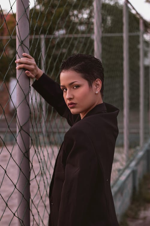 Girl with Short Hair Posing by a Net Fence