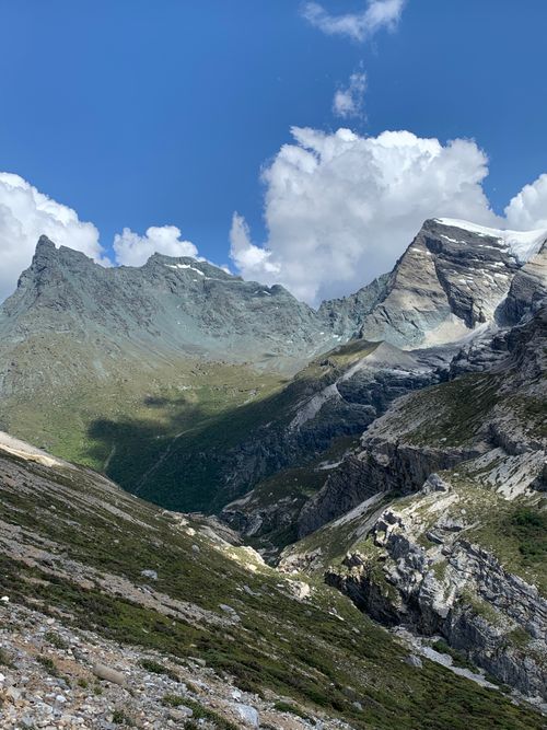 Free Majestic mountain range under a clear blue sky and fluffy clouds, captured in daylight. Stock Photo