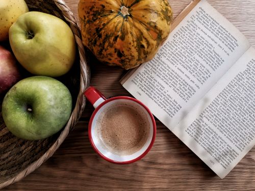 Free Cozy autumn still life with coffee, fruits, and open book on table. Stock Photo