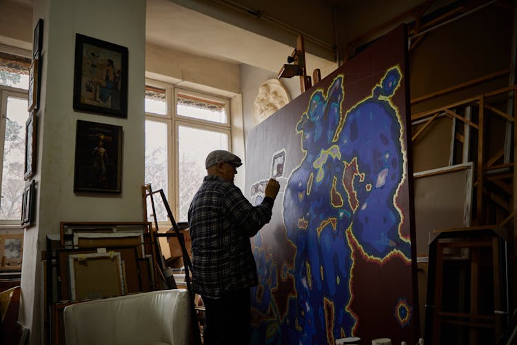 Photo Of An Artist Working On A Painting In A Studio