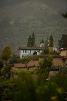 Explore a serene church nestled in the green hills of Tarma, Junín, Peru's tranquil countryside.