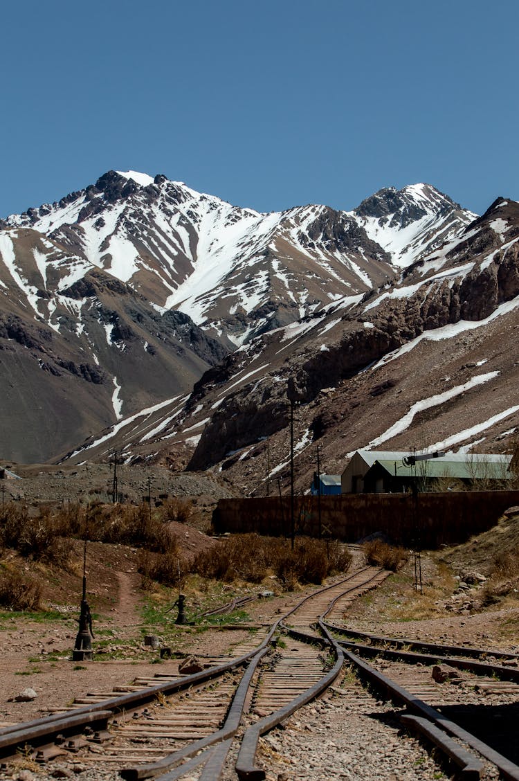 Brown Mountains With Snow And Railway Tracks