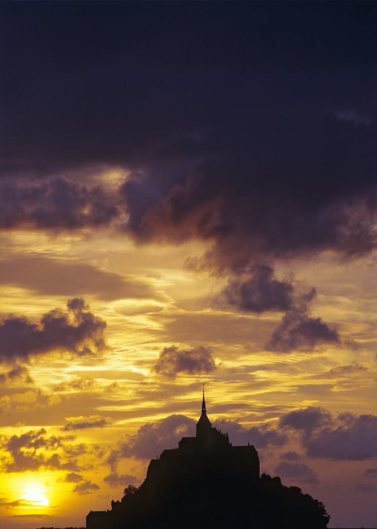 Silhouette Of Building Under Cloudy Sky During Sunset