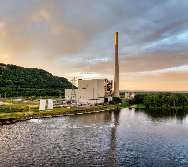 A scenic aerial view of Alma Power Station in Wisconsin at sunset, reflecting in river.