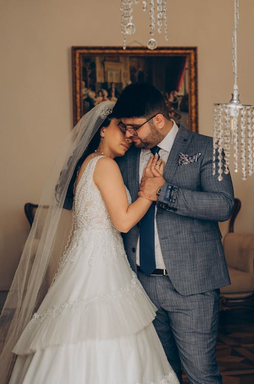 Newlyweds Cuddling in an Interior with Chandeliers