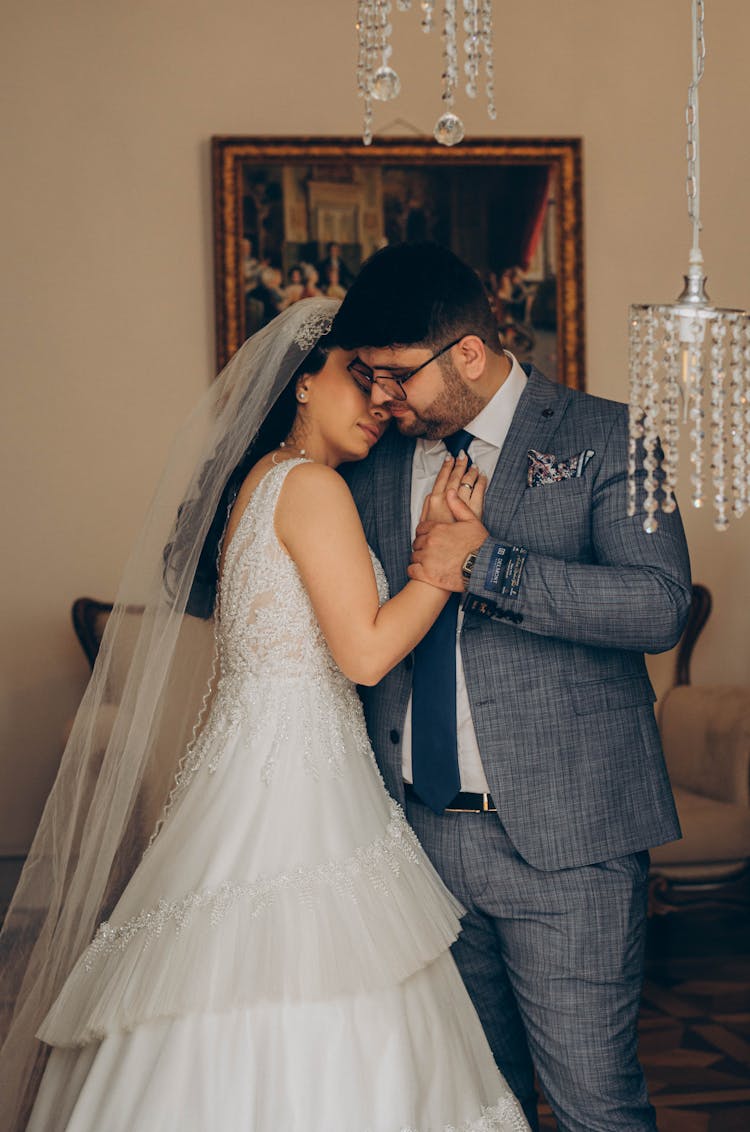 Newlyweds Cuddling In An Interior With Chandeliers