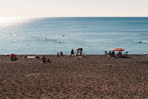 Free People enjoying a sunny day at the beach with clear skies and gentle sea waves. Stock Photo