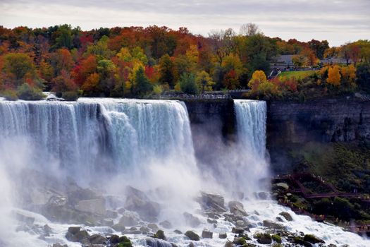 Stunning view of Niagara Falls with vibrant autumn foliage and cascading waterfalls.